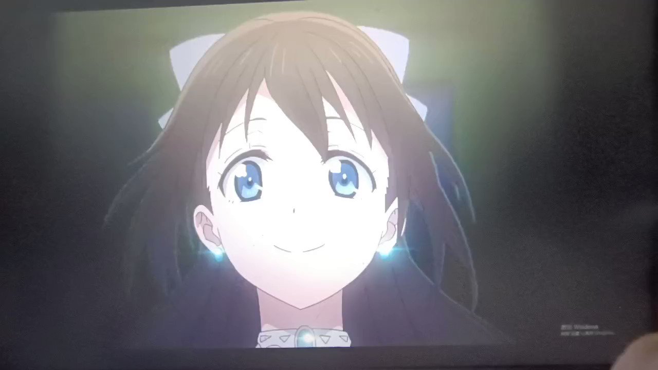 a closeup of an anime girl with long black hair, wearing a white necklace, with her eyes wide open and a smile on her face. the background is dark with a soft light shining around her.