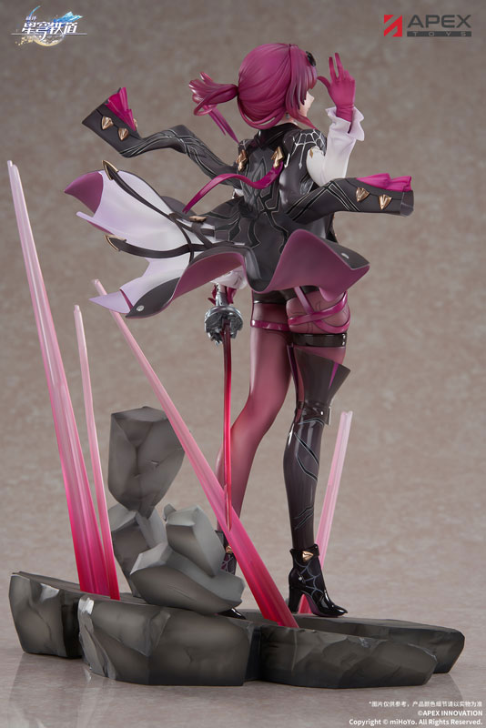 a figurine of kafka from the anime honkai star rail, made by apex toys. she has pink hair, and is wearing a black and pink outfit with boots. she is standing on a rock base with pink energy beams emanating from it. the figurine is viewed from the back.