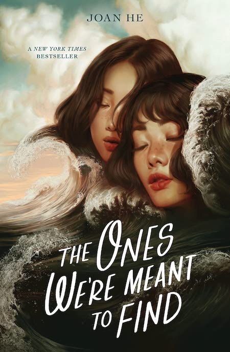 the book cover features two young women with long dark hair embracing each other. they are surrounded by large ocean waves and a sunset in the background. the title of the book, "the ones we're meant to find", is written in bold white lettering and is positioned in the lower portion of the cover. the author's name, "joan he", is written in a smaller white font at the top of the cover. the cover has a dreamy, romantic feel that suggests a story about love, loss, and finding your place in the world.