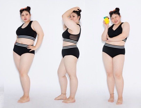 the image shows three plussize models wearing the same black and white twopiece swimsuit. each model is posed individually against a white background. the swimsuit consists of a highwaisted bikini bottom and a sports bra style top with white stripes. one model is holding a small pineapple toy. the overall mood is one of confidence and body positivity.