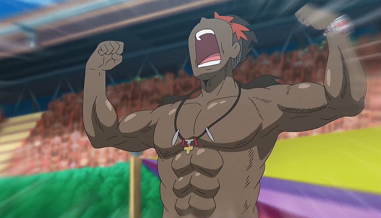 a darkskinned, muscular man with red hair is shown from the chest up, cheering with his arms raised in a crowded stadium. he is wearing a necklace and has a look of pure joy and excitement on his face. the background is blurred, suggesting movement and energy.