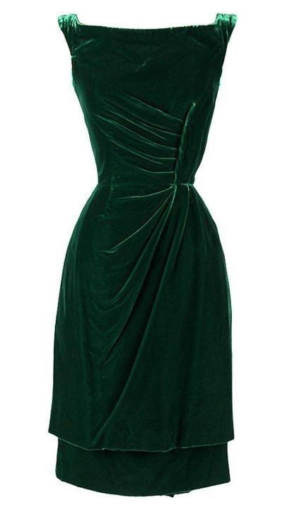 a stunning emerald green velvet dress with a scoop neck and sleeveless design. the dress features a ruched bodice and a fitted silhouette, which flows into a kneelength skirt. the dress is perfect for a formal event or a special occasion.
