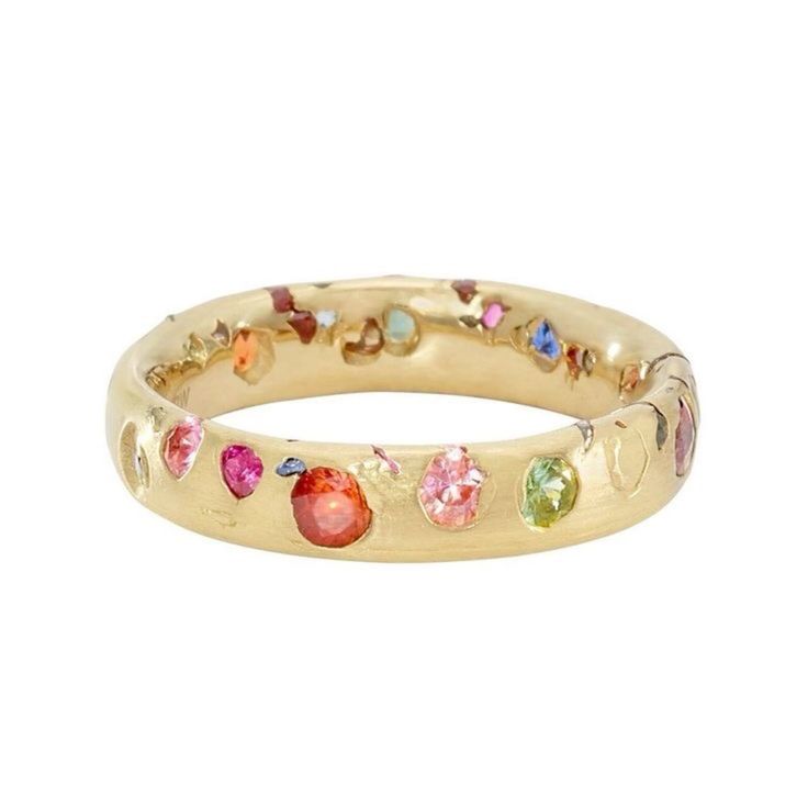 a gold band ring with many small, colorful gemstones set into the band. the ring is smooth and shiny.