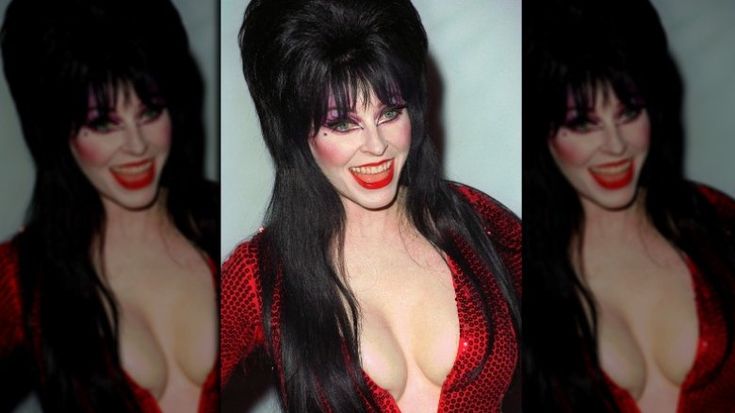 a woman with long black hair and a red sequined dress, smiling at the camera.  she is wearing a classic gothic style costume.  her red lipstick, black eyeliner, and dramatic eye makeup adds to her glamorous look.  this is most likely a posed portrait of a celebrity or actress.