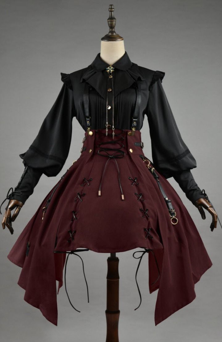 a mannequin displays a gothic lolita dress with a black highcollared, longsleeved, buttondown shirt, paired with a red corset and suspender skirt. the shirt features frills and a decorative cross. the corset is laced with ribbons, and the skirt has decorative ties. the overall aesthetic is dark, romantic, and elaborate.
