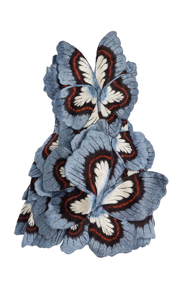 a dress made from large, stylized butterflyshaped petals is displayed against a white background. the petals are predominantly blue with darker borders, white patches, and a touch of reddishbrown, creating a layered and textured effect that mimics a whimsical floral or butterfly design.