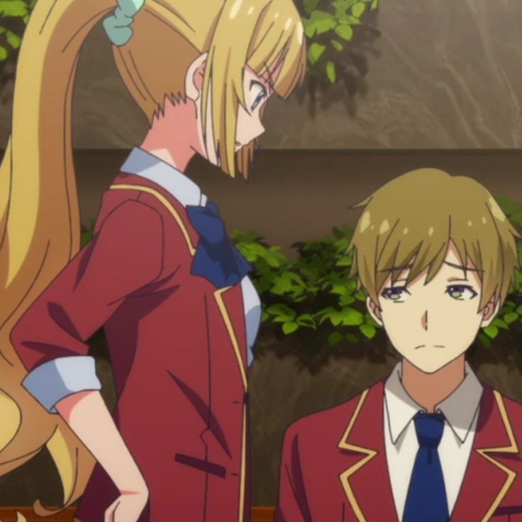 the image is a closeup of two anime characters. both are wearing a school uniform with a red jacket and gold accents. the girl on the left has long blond hair tied up in a ponytail with a blue bow, and she looks stern.  the boy on the right has brown hair and a blue tie. he looks sad.