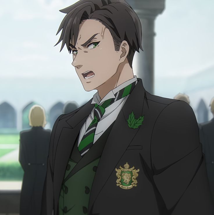 a close up of an anime character with green eyes and brown hair. he is wearing a black suit with a green tie and vest. he is also wearing a green leaf pin on his lapel and a gold lion badge. his face is twisted into an angry expression.  he is standing in front of a blurry background of other students, possibly in a school setting.