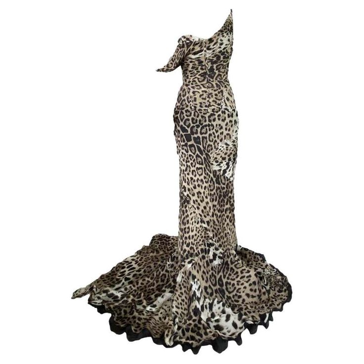 a long, flowing leopard print dress with a single strap. the dress is made of silk and has a fitted bodice and a full skirt. the dress is very glamorous and would be perfect for a special occasion. the dress is also vintage and dates back to the 1990s. it is a designer piece and is very highfashion.