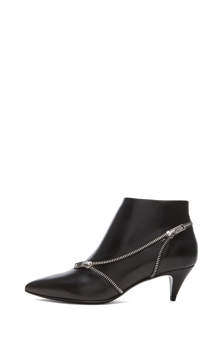a black ankle boot with a zipper design across the upper, set against a white background.