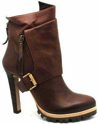 a pair of brown leather ankle boots with a buckle strap on the top of the foot. the boots have a high heel and a chunky sole. the boots are made of high quality leather and have a stylish design.