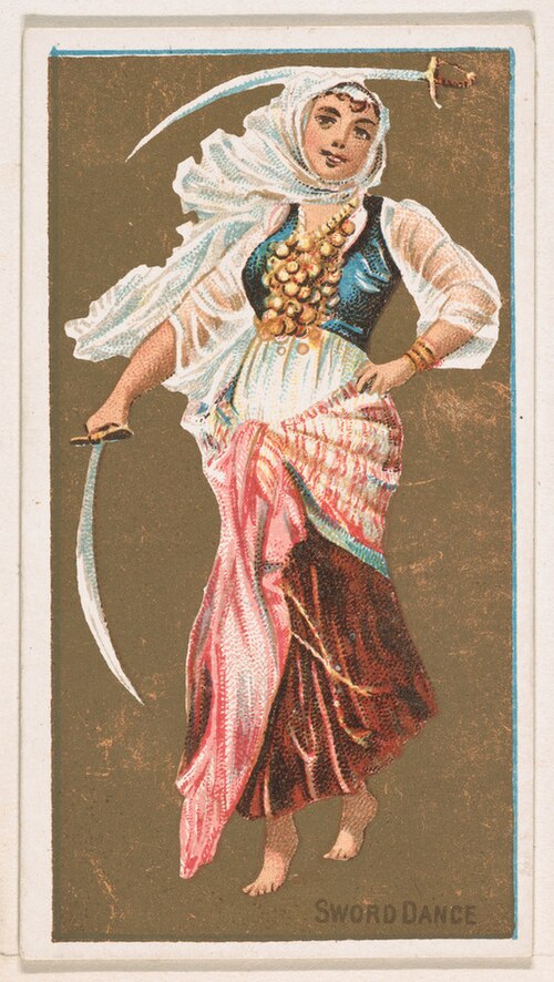 a woman in a traditional costume is performing a sword dance. she is wearing a headscarf, a blue vest, a white shirt, and a long skirt. she is holding a sword in her right hand.