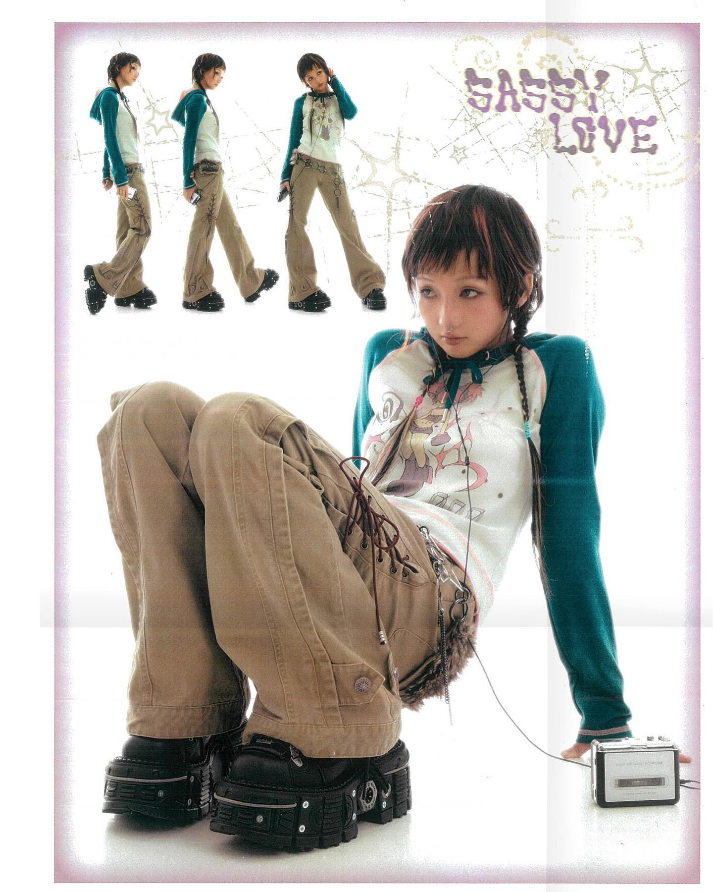 a full shot of a young woman wearing a teal and white raglan shirt and khaki cargo pants poses in a studio setting.  she's wearing chunky black platform boots and has a cassette player on the ground near her.  the background features a stylized "sassy love" graphic and three smaller images of the model in a similar pose but wearing different shirts.  the overall style is reminiscent of early 2000s alternative fashion with a touch of anime/manga influence.