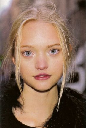 closeup portrait of a young woman with blonde hair, blue eyes and light skin. she is wearing a black jacket. the photo is taken in a casual setting. the woman is looking directly at the camera. her makeup is natural and her skin is clear.