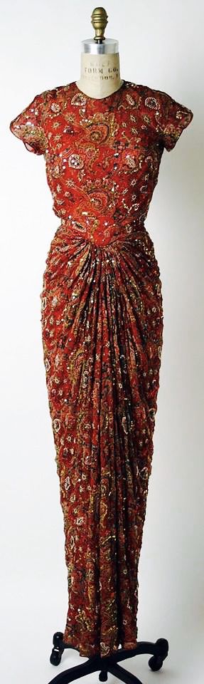 a vintage red dress with sequins and beads, a glamorous evening gown, formal occasion wear,  a classic style.