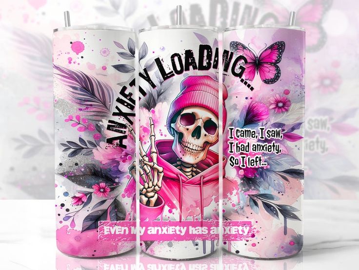 three tumblers with an anxiety theme are pictured. the center tumbler features a skeleton in a pink hoodie and beanie with the words "anxiety loading" above it. the tumblers on either side have flowers and butterflies. one of the tumblers also has the text "i came, i saw, i had anxiety, so i left..." and "even my anxiety has anxiety".