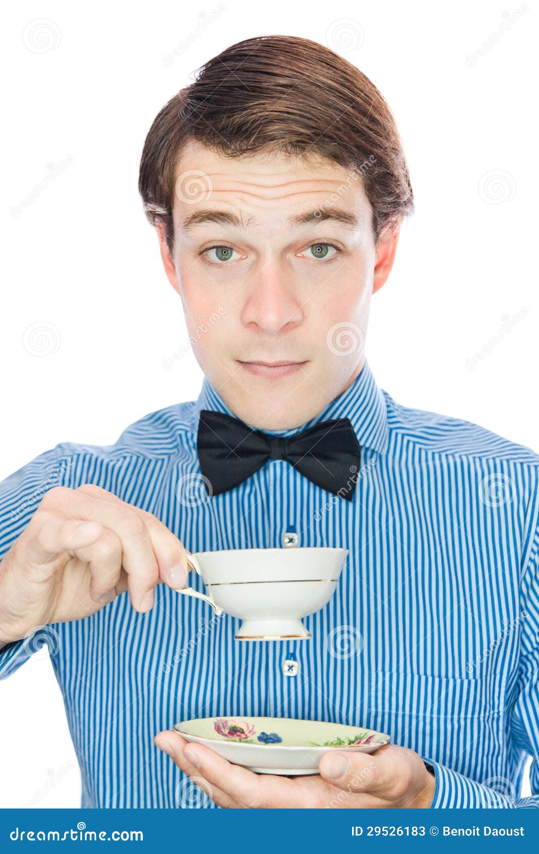 a closeup portrait of a young, attractive caucasian man with short brown hair neatly combed back. he's wearing a blue and white striped dress shirt and a black bow tie. he's holding a delicate teacup and saucer with both hands.  his expression is thoughtful and calm as he seems to be about to take a sip of tea. the background is pure white, emphasizing the subject and creating a clean, professional look.  the overall style is elegant and sophisticated.
