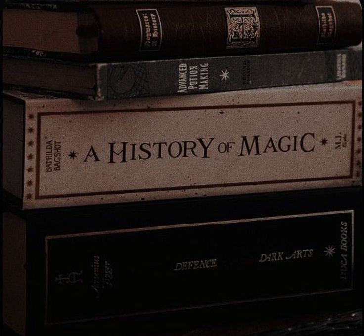 a stack of fictional books from the harry potter universe. the top book is a history of magic by bathilda bagshot. underneath is advanced potion making.  the other books are defense against the dark arts and other magical subjects.