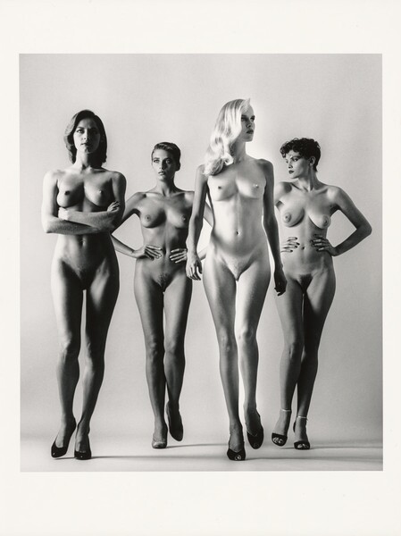 the black and white photograph shows four nude female models standing in a row against a light grey background.  they are positioned in a slightly staggered line. each model is slender with long legs, and they are all wearing simple highheeled shoes.  their poses are relatively static and unemotional, creating a minimalist and almost sculptural effect. the style suggests a fashion or art photography shoot from the late 20th century. the overall mood is one of classic elegance and calm.