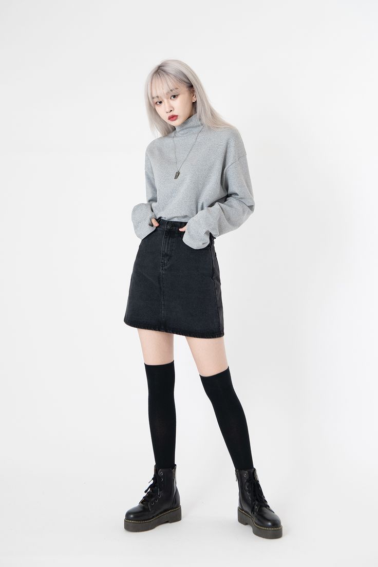 a fullbody shot of a young asian woman in a minimalist outfit against a white background. she's wearing a light grey turtleneck sweater, a black denim mini skirt, black kneehigh socks, and black combat boots. her hair is styled in a straight, pale blonde bob.  she's looking down slightly, and her hands are in her pockets.  the overall style is simple, clean, and slightly edgy.