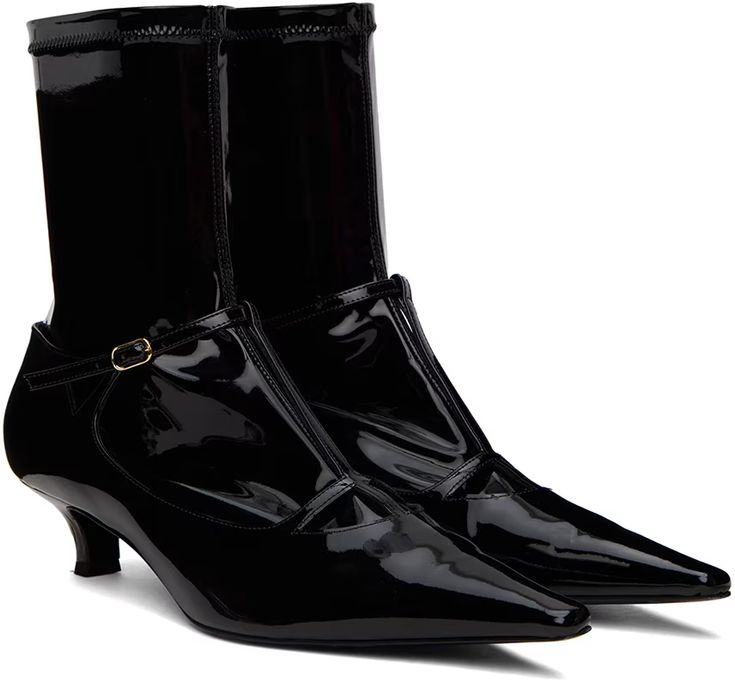 a pair of glossy black patent leather ankle boots with a pointed toe and a slim heel. the boots have a strap with a buckle detail near the ankle and a socklike upper extending above the ankle.