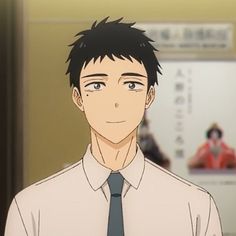 the image shows a digital illustration of a young man with short black hair and dark eyes. he's wearing a white buttonup shirt with a dark teal tie. he is smiling softly with his eyes partially closed. the background suggests he is standing inside of a train station with a poster hanging behind him, though it's out of focus.  the lighting is soft, giving the image a gentle and approachable feel.
