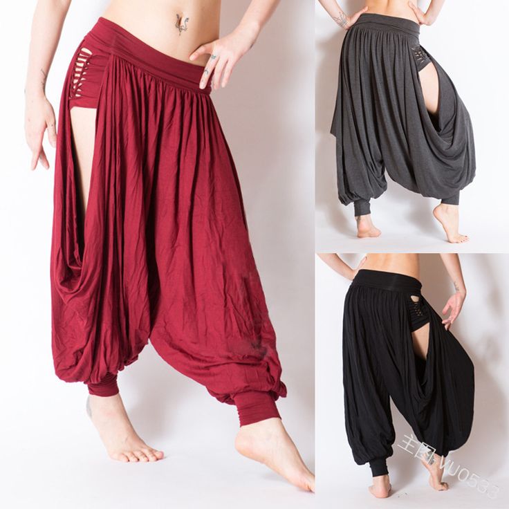 three women are showcasing different variations of harem pants. the woman on the left is wearing a vibrant red pair with a side slit, while the woman in the middle is donning a dark gray pair. the woman on the right is showing off a black pair with a side slit. all three women are rocking the freespirited and relaxed vibe of these stylish pants.