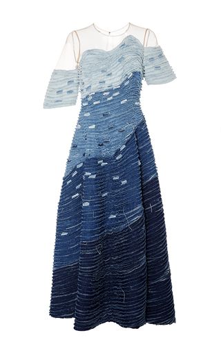 a floorlength denim dress. the dress has a gradient color, transitioning from light blue at the top to dark blue at the bottom. it also has a sweetheart neckline and short sleeves.