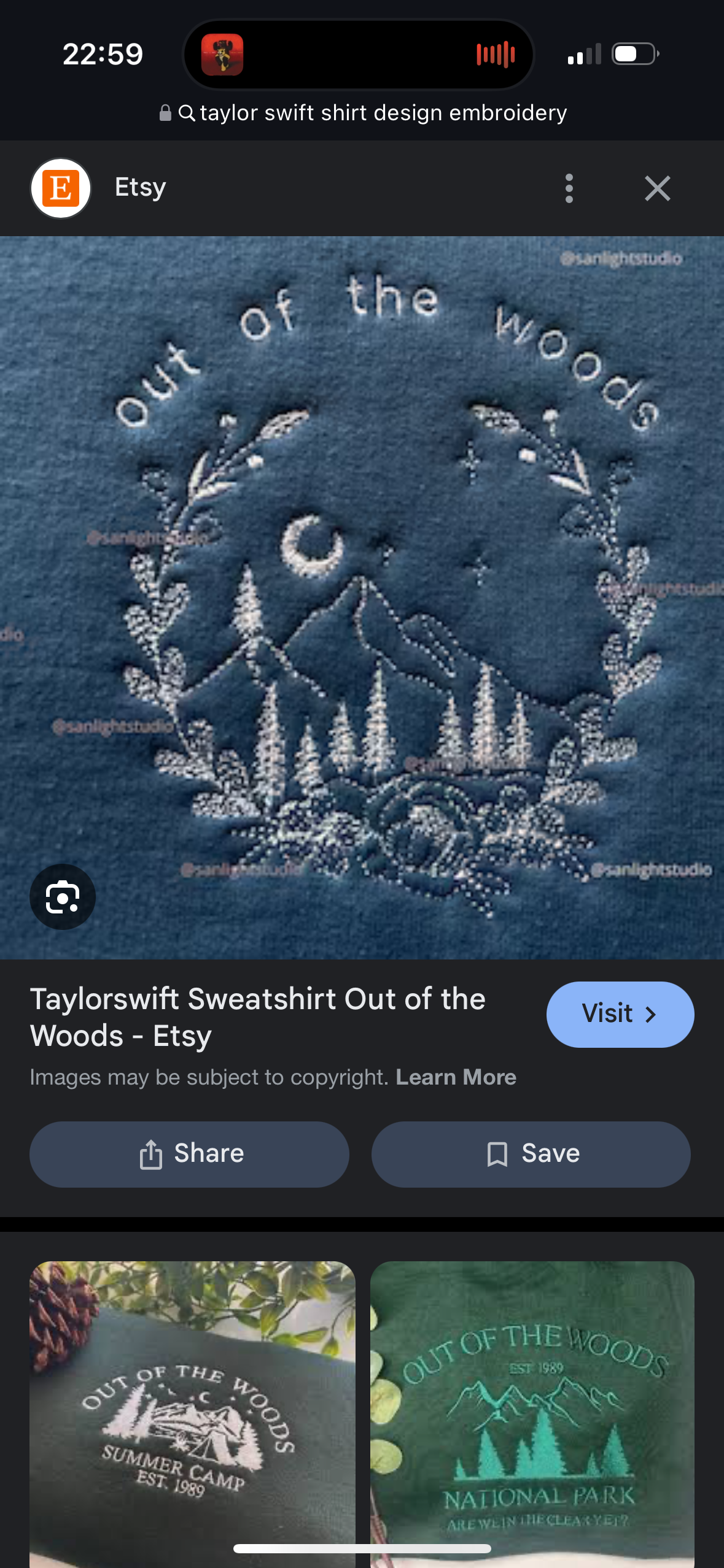 the image is an advertisement for a taylor swift sweatshirt featuring the phrase "out of the woods" embroidered on the front. the embroidery depicts a forest scene with mountains, a moon, stars, floral elements, and a line of trees. the sweatshirt is available for purchase on etsy. the advertisement also features images of the sweatshirt design being worn on a green sweatshirt and a dark green sweatshirt.