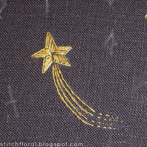 a gold shooting star embroidered on a dark gray fabric.