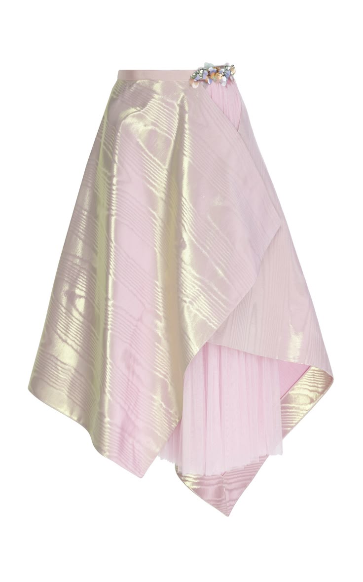 a pink skirt with a beaded embellishment on the waistband is displayed on a white background. the skirt has an iridescent fabric with a textured pattern. the skirt is asymmetrical in shape, with a shorter layer of pink tulle peeking out from underneath.