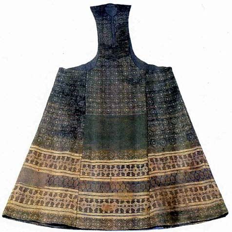 an image of an ornate vintage dress, featuring a high neck, a dark geometric pattern, and a goldcolored design along the bottom. the dress is flared at the bottom and appears to be constructed from a rich fabric. the image is presented on a plain background.
