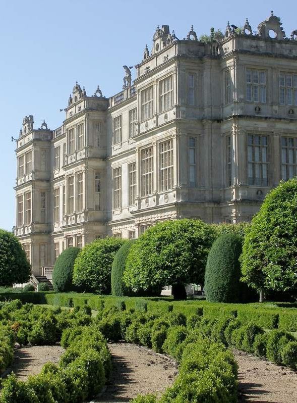 the image showcases castle howard, a magnificent baroquestyle country house in yorkshire, england.  the main focus is on the impressive facade of the house, displaying its symmetrical design, numerous windows, and ornate details.  the foreground features meticulously manicured formal gardens with neatly trimmed hedges and topiary, creating a contrast between the grandeur of the building and the structured elegance of the landscaping. the scene is bathed in bright sunlight, suggesting a summer day. the overall impression is one of historical significance, architectural beauty, and the idyllic charm of a stately home's grounds.