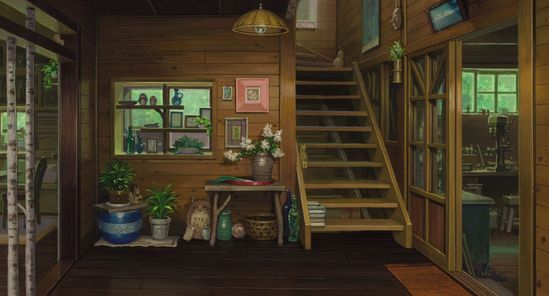 the image is of the interior of a rustic wooden house. the scene shows a small entryway or foyer, with a wooden staircase leading to the second floor. to the left is a sliding glass door that is mostly obscured by birch tree trunks. sunlight filters through the glass and casts bright patches on the dark wooden floor.  there are potted plants on stands near the door, and a low table next to the stairs holds a vase of white flowers. pictures and framed artwork decorate the wall, and a window looking out to the yard is to the left of the stairs. the overall feel is warm, inviting, and full of natural light.