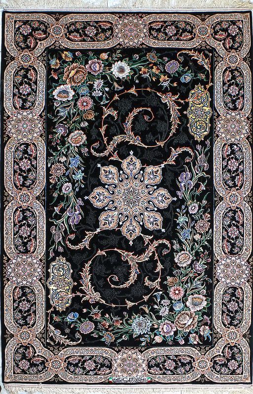 the image shows a detailed and ornate oriental rug, likely a persian carpet, featuring an intricate floral pattern on a black background. the rug has a rectangular shape with a wide border adorned with floral designs. the central area of the rug is decorated with flowers and swirling patterns, including a large central medallion. the overall impression is one of luxury, craftsmanship, and traditional design.