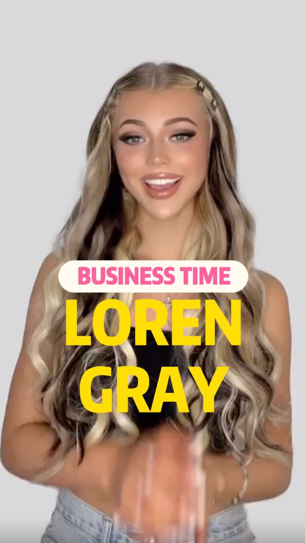 a woman with blonde hair, wearing makeup and a denim jacket is smiling at the camera. text is superimposed on the image that reads "business time" and "loren gray".