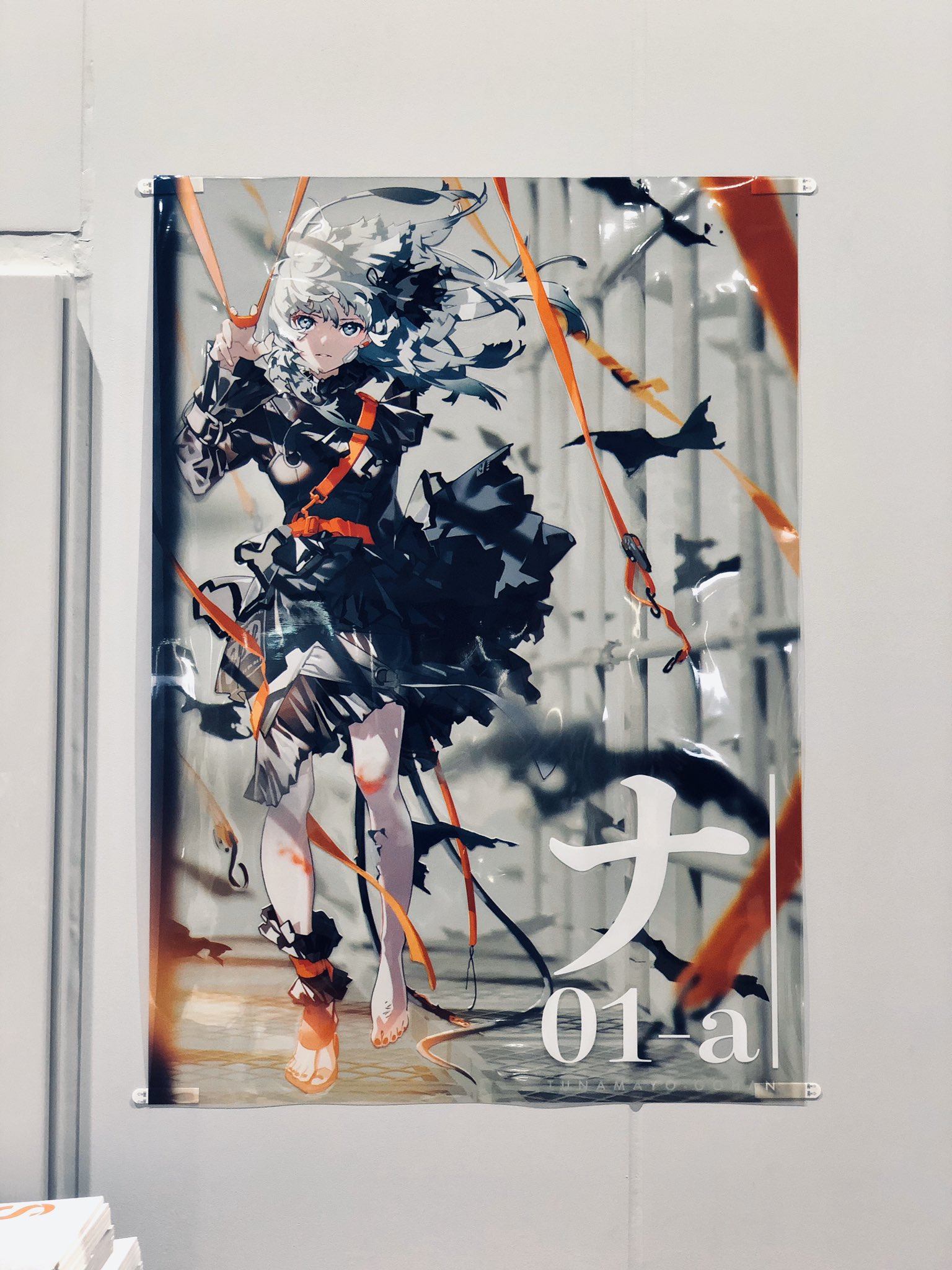 a dynamic poster featuring an anime girl with white hair and a black dress. she is in midair, her pose suggesting action. orange ribbons weave through the image, adding a sense of movement. the poster is mounted on a white wall, illuminated by artificial light. the perspective is at eye level.