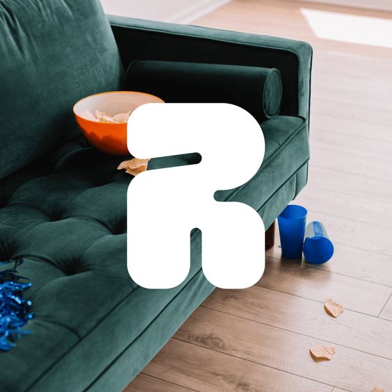 a highangle view of a messy green couch with an empty orange chip bowl, spilled chips, and cups on the floor. the image evokes a sense of a recent party or gathering.