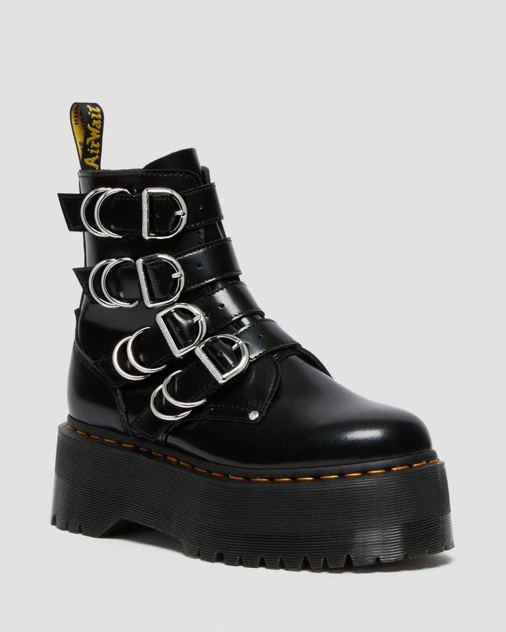 a single black dr. martens platform boot stands upright on a plain background. the boot features shiny black leather, a thick platform sole, and multiple straps with silver buckles encircling the ankle. the airwair label is visible on the back of the boot.