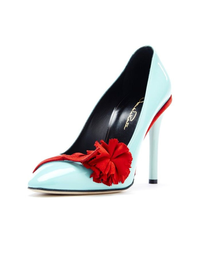 a light blue, highheeled pump with a red flower embellishment on the front. the shoe has a pointed toe and a stiletto heel. the inner lining is black, and the shoe is marked with the oscar de la renta logo.