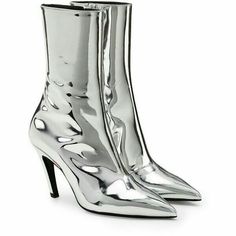 a pair of silver stiletto boots with pointed toes. the boots are made of a metallic material and have a high heel. the boots are shown on a white background. they are a stylish and elegant choice for any occasion.