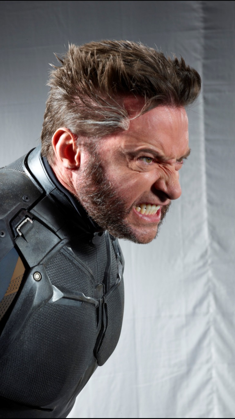 a closeup portrait of hugh jackman as wolverine from the xmen franchise. he is wearing a black and grey costume, clenching his teeth in a grimace, conveying anger. his signature claws are not visible in this shot.