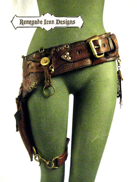 this photo shows a brown leather, steampunkstyle belt and holster on a green dress form. the belt is made of several different pieces of leather, all in different shades of brown. the holster is attached to the belt with a series of buckles and chains, and it has a small pouch on the front. the belt is decorated with brass rivets, buckles, and chains.