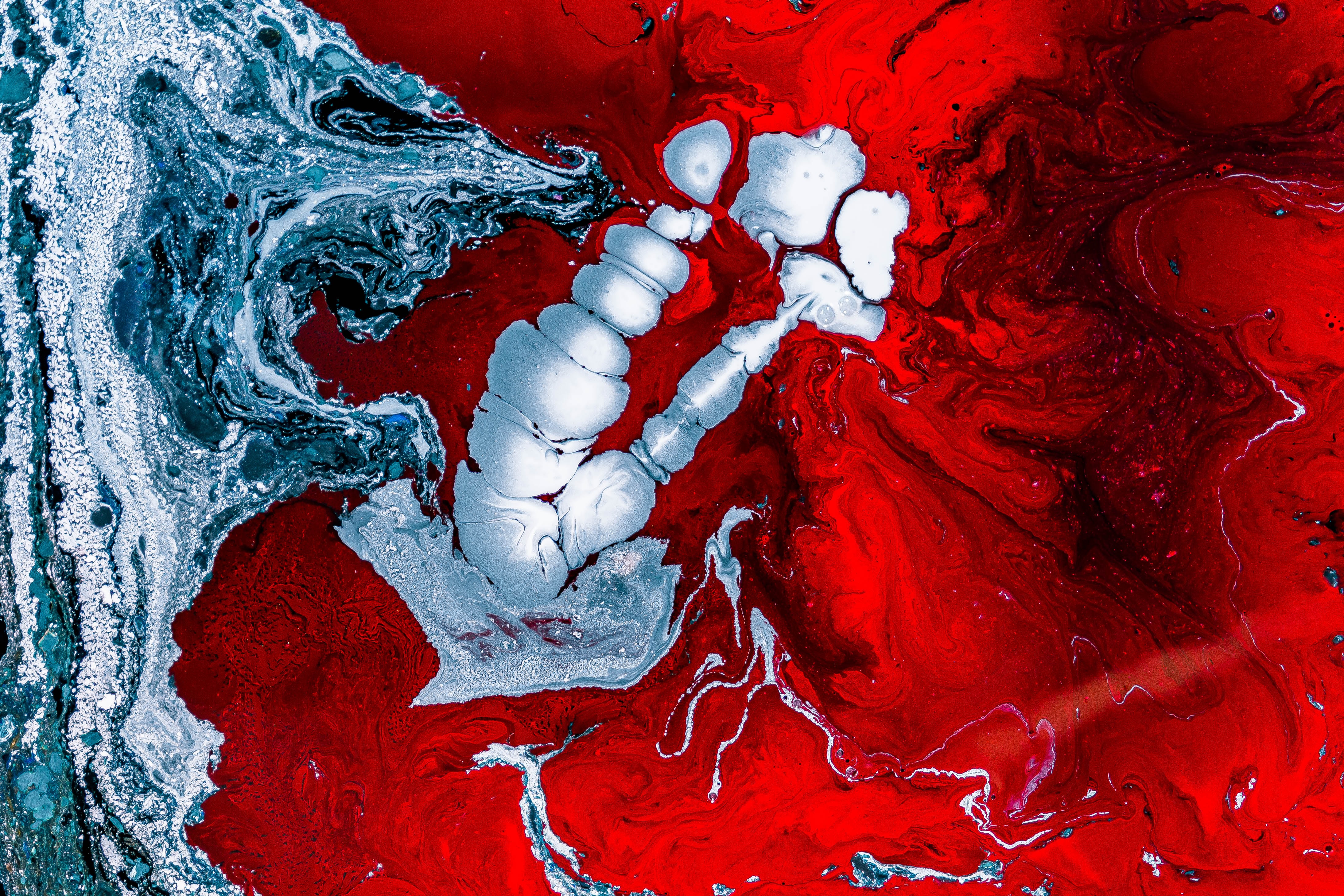 close up of an abstract painting with red, white and blue paint swirls. the painting is created using a fluid art technique, where paint is poured onto a canvas and allowed to flow and mix freely. the result is a beautiful and abstract piece of art.