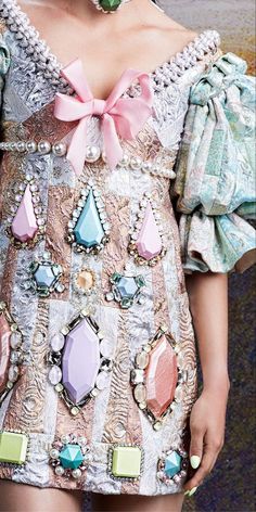 a closeup view of a fashion model showcasing an intricate, pastelhued dress adorned with an abundance of shimmering gems. the dress features a white lace bodice, a pink bow, and a delicate, shimmering fabric that reflects the light. the model's hair is hidden from view, and the dress is the focus of the image. the dress is designed for a special occasion and exudes elegance and sophistication. the overall effect is one of refined glamour and captivating detail.