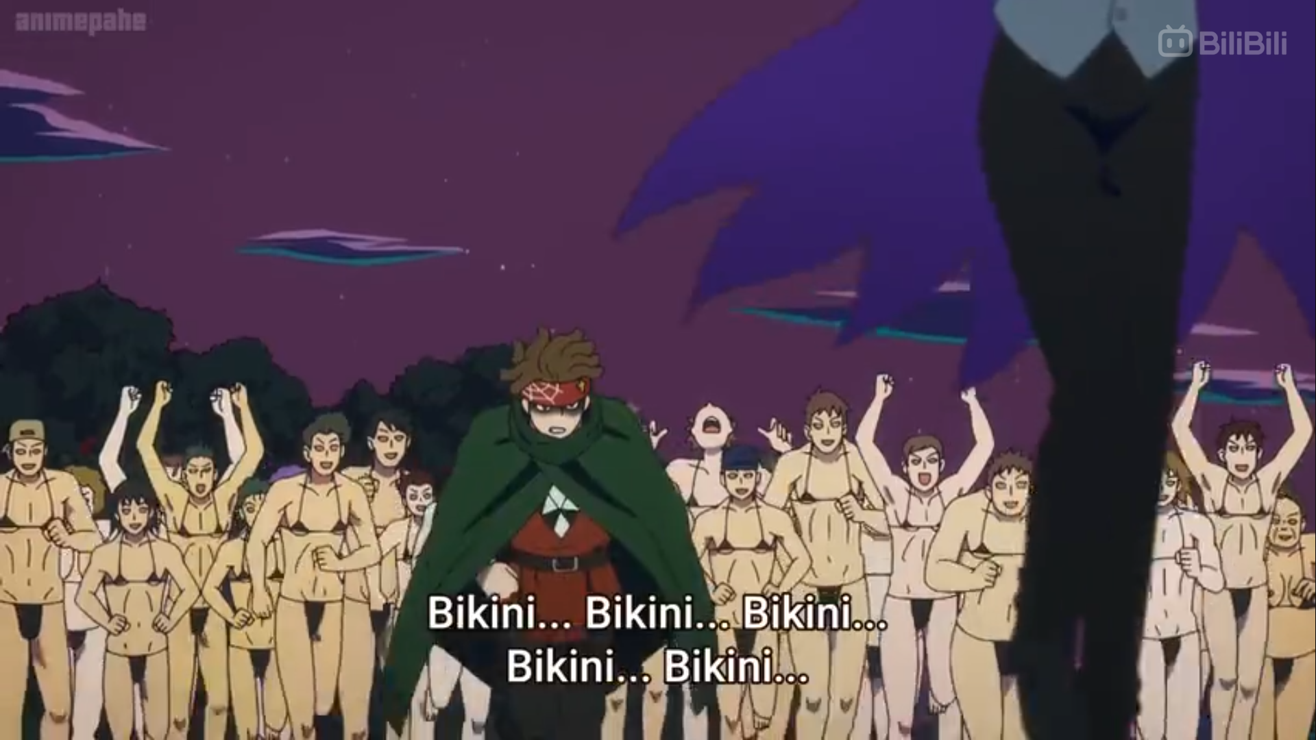 a large group of people, mostly unclothed men, are running towards the viewer at night in what looks like a forest. they are all chanting "bikini". there is a cloaked person at the front of the crowd, facing the viewer.