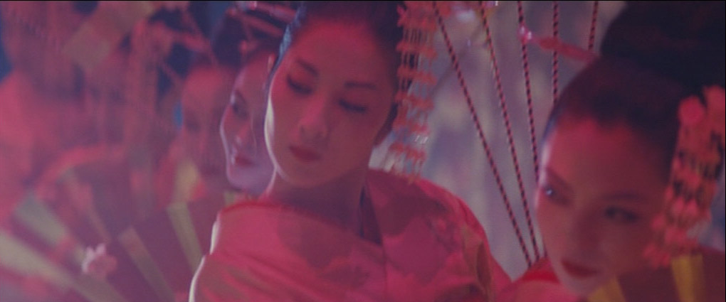 a medium shot of a group of four asian women in traditional geisha attire dancing with red fans. the background is dark and colorful, lit with neon lights. the overall image gives a sense of drama and motion.