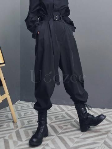 a fullbody shot of a model wearing a stylish black outfit. the outfit consists of loosefitting, highwaisted pants with a belt, and black combat boots. the pants are baggy and comfortablelooking. the model is standing on a gray tiled floor with geometric designs. the background is a plain gray wall. the overall style is streetwear, suitable for fall or winter.