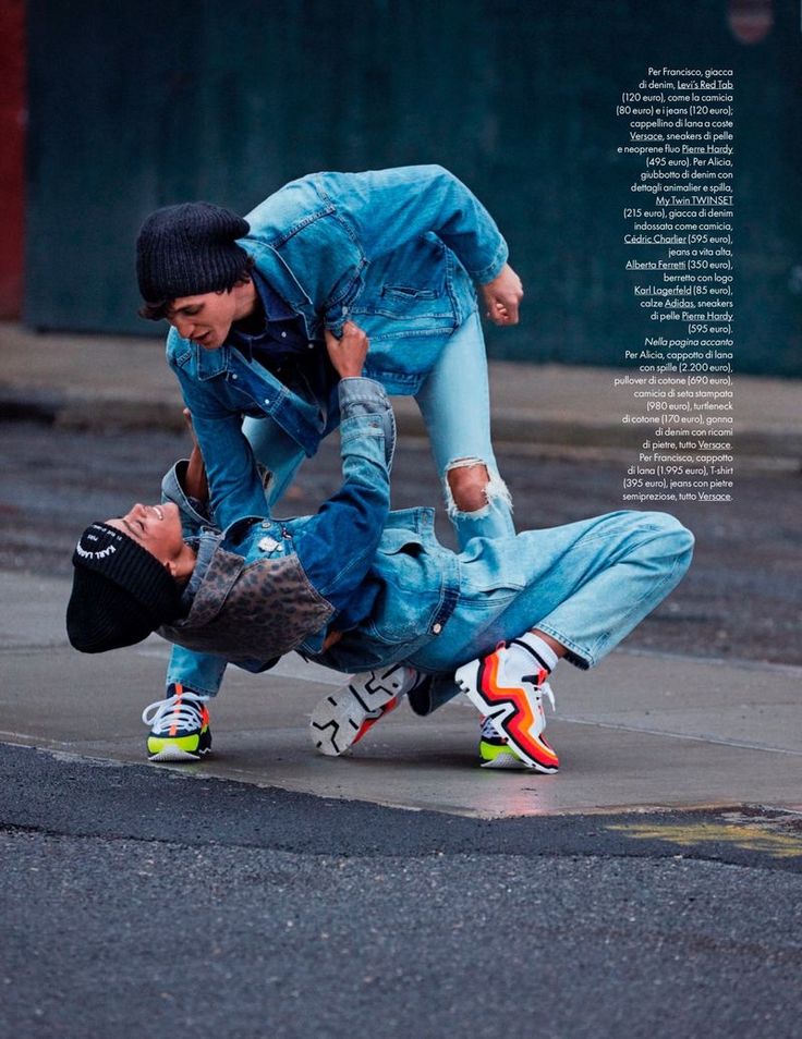 two models are posing in a street setting. both are wearing denim jackets, jeans, and sneakers. the model in the back is wearing a black beanie, while the model in the front is wearing a leopard print vest. they are both posing in a dynamic, streetstyle way. the image is a fashion shoot for a streetwear brand.