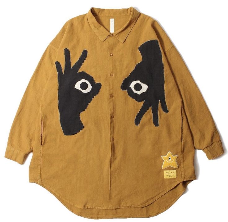 a brown, oversized buttondown shirt with long sleeves. it features two large black hands embroidered on the front, with each hand making the "okay" sign. the hands have large white eyes on them, and the center of the shirt has a small yellow star patch.